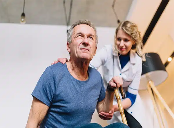 A professional massage therapist applying focused thumb pressure to the arch and ball of a patient's foot during a therapeutic reflexology session.