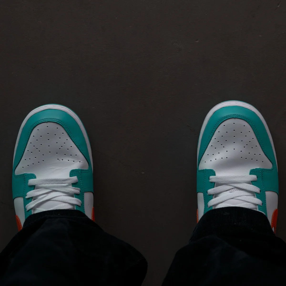 Looking down at supportive shoes while standing all day on a hard floor