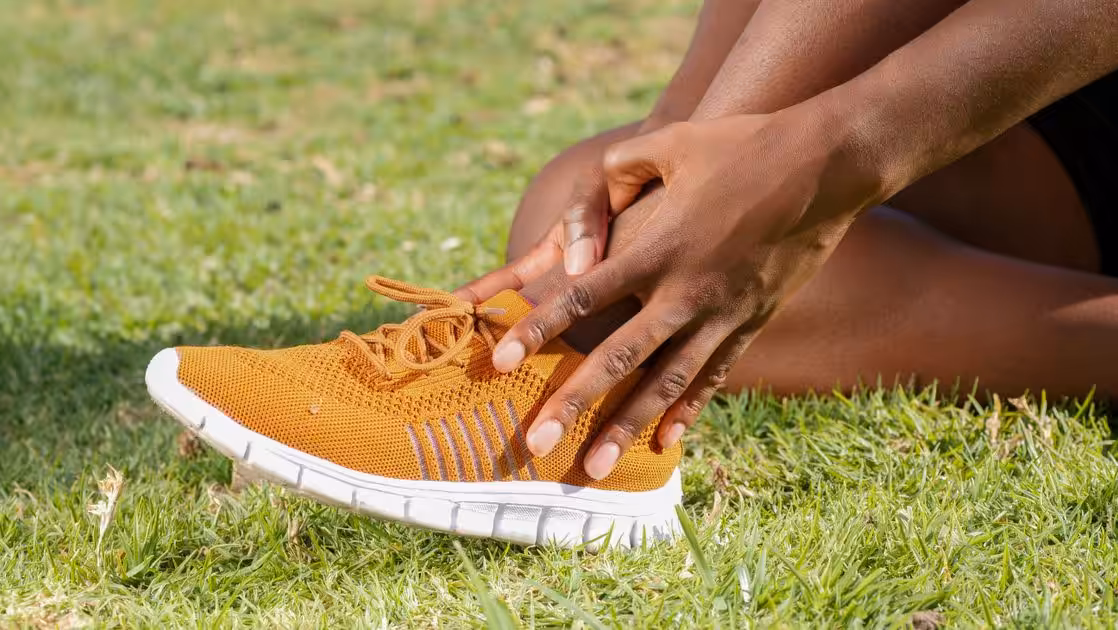 Runner gripping the ankle after a misstep — running injury prevention, Balance Foot & Ankle, Howell MI