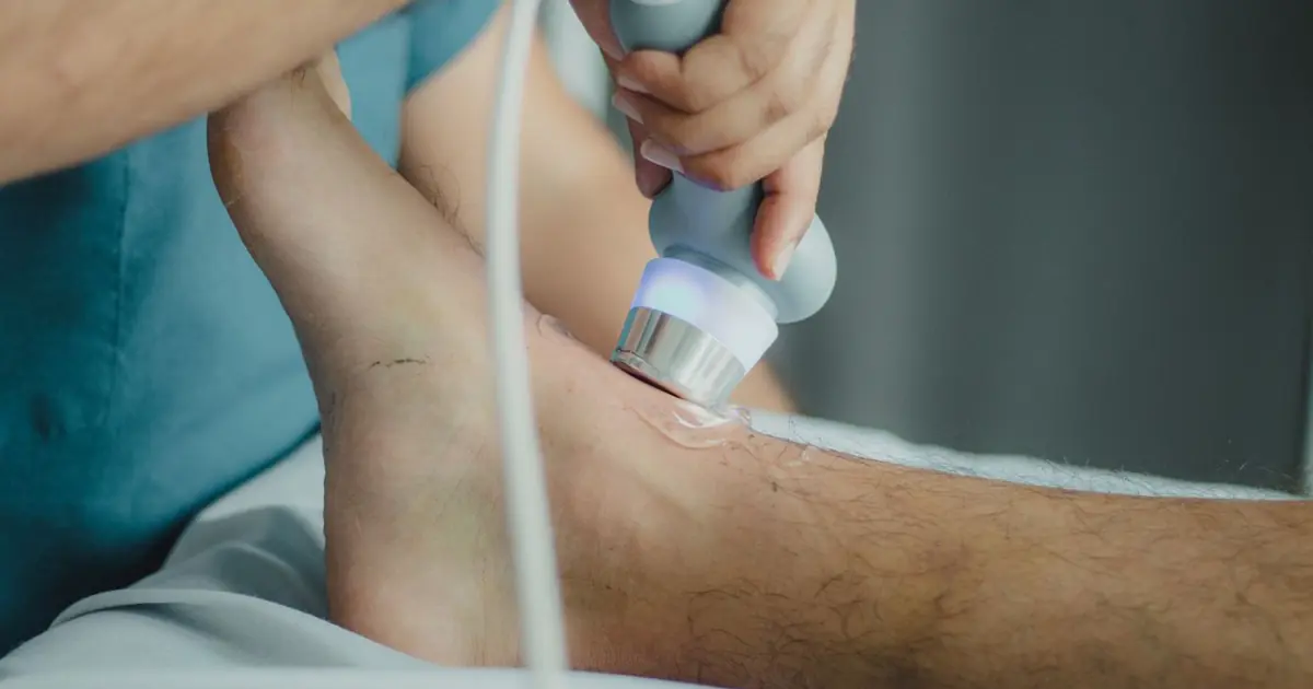 Podiatrist using medical laser device on foot — laser toenail fungus treatment, Balance Foot & Ankle, Howell MI