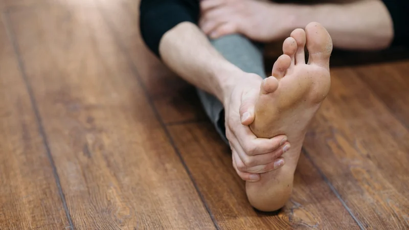 Bare foot being stretched on the floor for plantar fasciitis relief - Balance Foot & Ankle, Howell MI