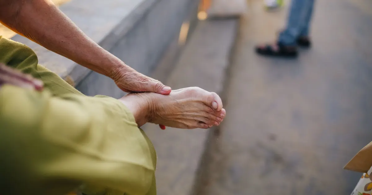Older adult rubbing a sore, tired foot - best shoes for edema and swollen feet, Balance Foot and Ankle, Howell MI